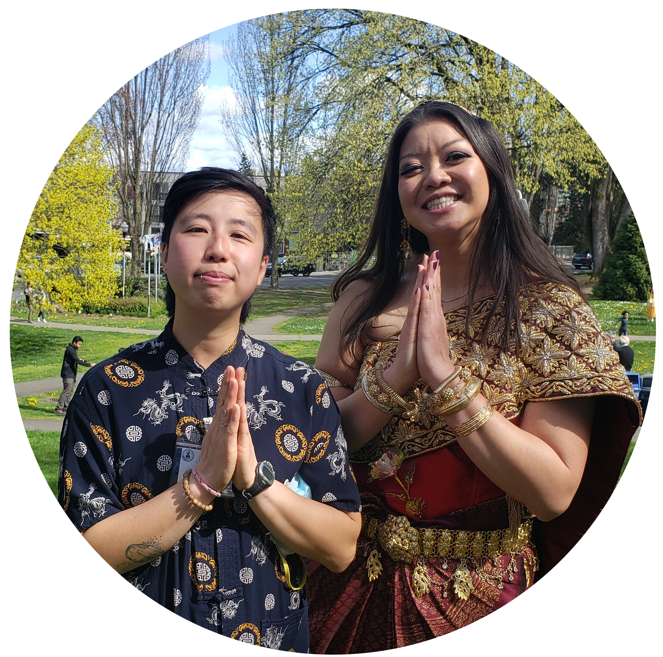 Stephanie and Dana stand next to each other in a park, their hands folded in a prayer position.